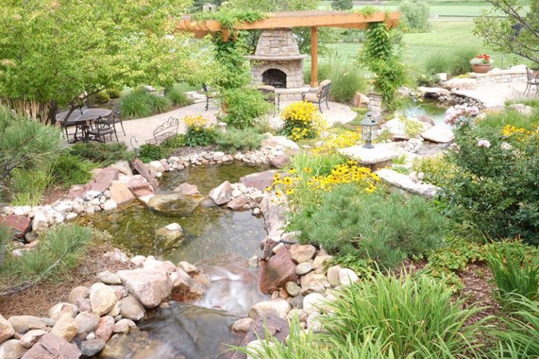 Large waterfall and ponds with outdoor fireplace and patio