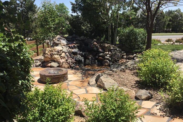 waterfall and firepit on a flagstone patio
